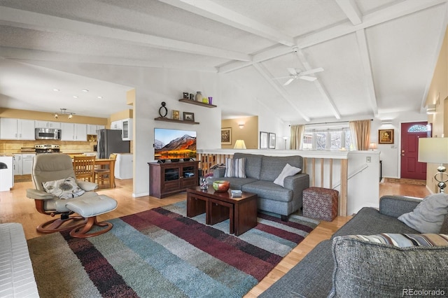 living room featuring a ceiling fan, light wood-type flooring, and vaulted ceiling with beams