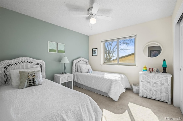 carpeted bedroom with a ceiling fan and a textured ceiling