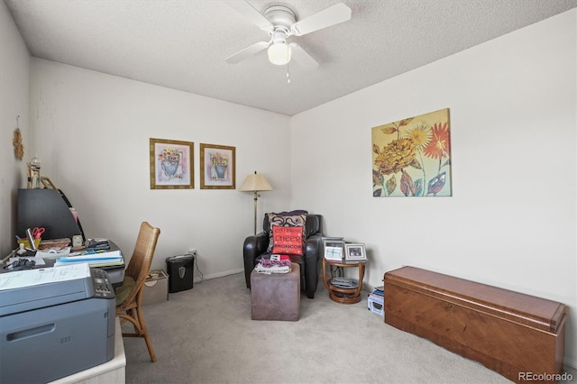 carpeted home office with ceiling fan and a textured ceiling