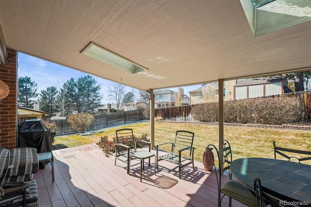 wooden terrace with a fenced backyard, grilling area, and a yard