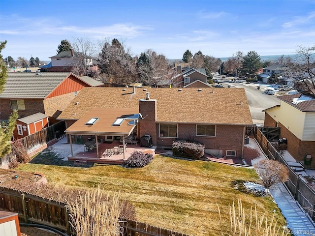 back of property featuring a patio, brick siding, a lawn, and a fenced backyard