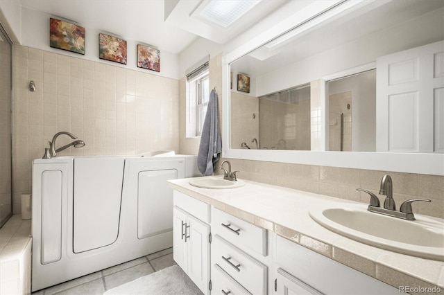 4621 S Perry Way, Denver, CO 80236 - bathroom with a bath, tile patterned floors, double vanity, tile walls, and tiled shower
