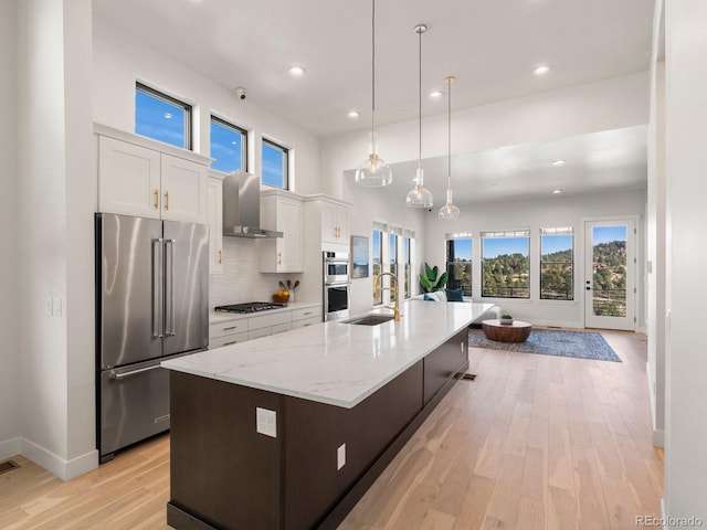 kitchen featuring white cabinetry, appliances with stainless steel finishes, an island with sink, and plenty of natural light