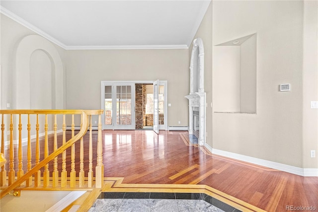 corridor with ornamental molding, a baseboard radiator, baseboards, and wood finished floors