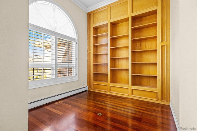 spare room featuring a baseboard heating unit, dark wood-style flooring, and crown molding