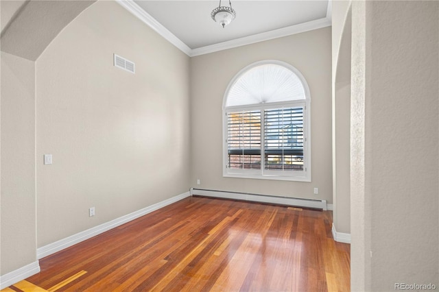 unfurnished room featuring wood finished floors, visible vents, baseboards, baseboard heating, and crown molding