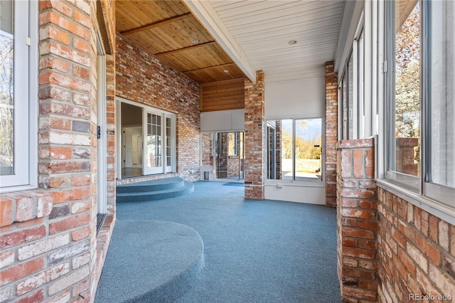 unfurnished sunroom featuring wood ceiling and beam ceiling