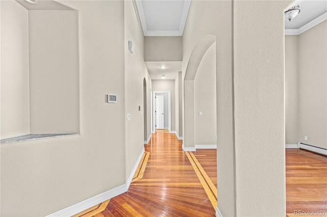 corridor with baseboards, light wood-style floors, and crown molding