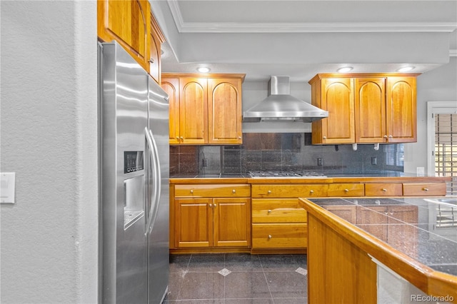 kitchen with crown molding, decorative backsplash, appliances with stainless steel finishes, brown cabinetry, and wall chimney exhaust hood