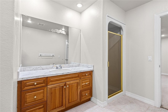 full bathroom featuring a stall shower, baseboards, visible vents, and vanity