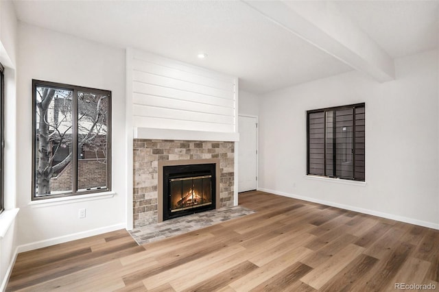 unfurnished living room featuring hardwood / wood-style floors and beamed ceiling