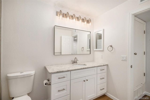 bathroom featuring vanity and toilet