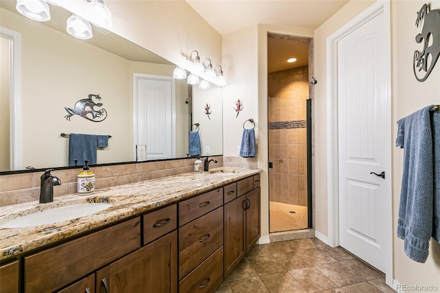 bathroom featuring vanity, a tile shower, and tile patterned floors