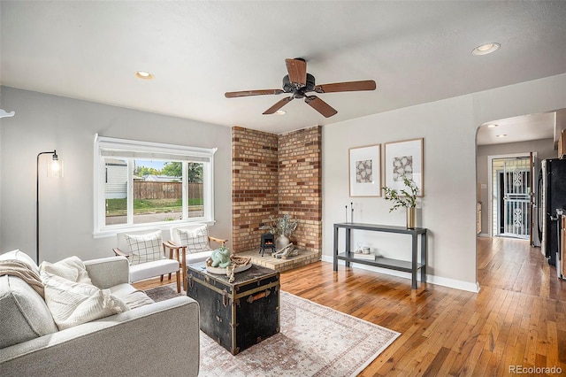 living room featuring ceiling fan and hardwood / wood-style flooring