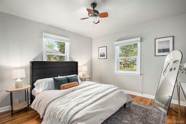 bedroom with ceiling fan, hardwood / wood-style floors, and multiple windows