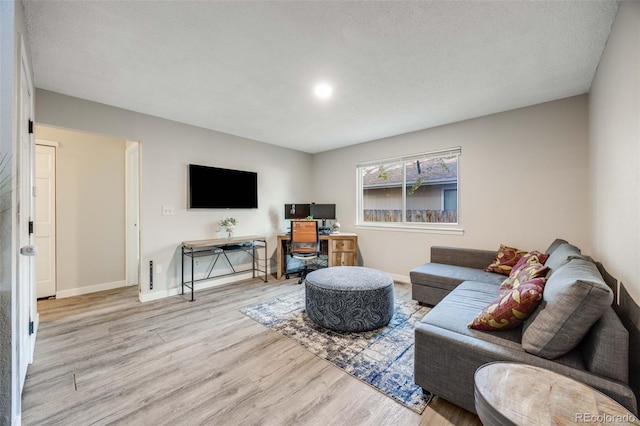 living area with baseboards and wood finished floors