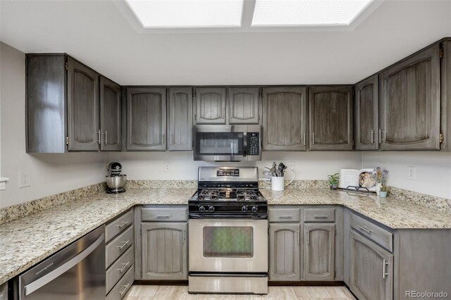 14867 E Pacific Pl, Aurora, CO 80014 - kitchen featuring light wood-type flooring, stainless steel appliances, and light stone counters