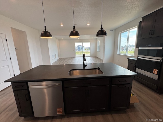 2141 S Irvington St, Aurora, CO 80018 - kitchen featuring stainless steel dishwasher, wood finished floors, a center island with sink, recessed lighting, and decorative light fixtures