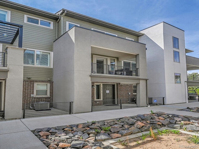 4245 E Iliff Ave Unit 2, Denver, CO 80222 - rear view of property with cooling unit, brick siding, a patio area, a balcony, and stucco siding