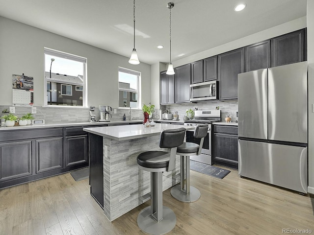 4245 E Iliff Ave Unit 2, Denver, CO 80222 - kitchen with tasteful backsplash, stainless steel appliances, light wood-style floors, and light countertops
