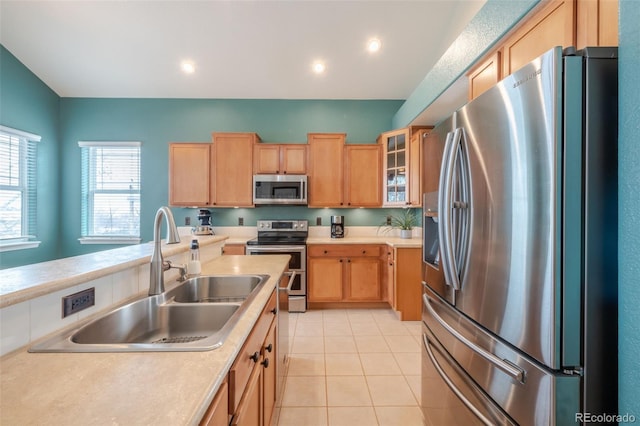 kitchen featuring stainless steel appliances, sink, and light tile patterned floors