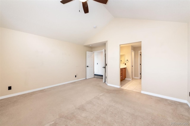 unfurnished bedroom featuring high vaulted ceiling, ensuite bath, light colored carpet, and ceiling fan