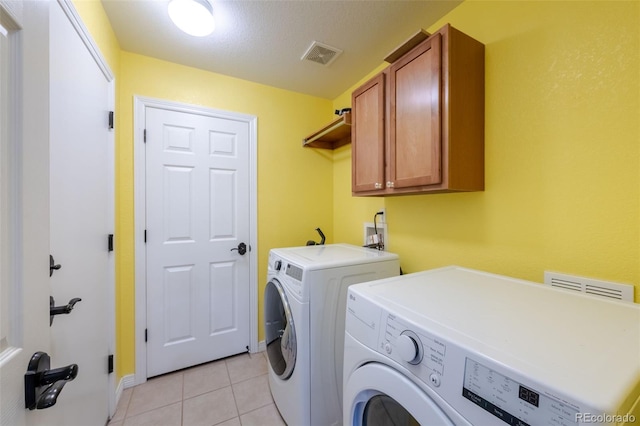 washroom with cabinets, independent washer and dryer, and light tile patterned flooring