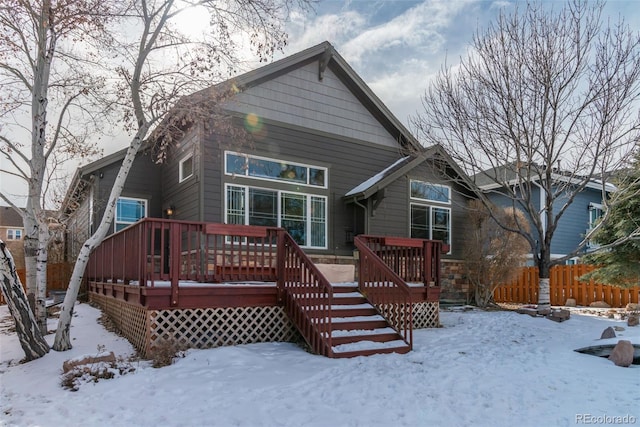 snow covered house featuring a deck