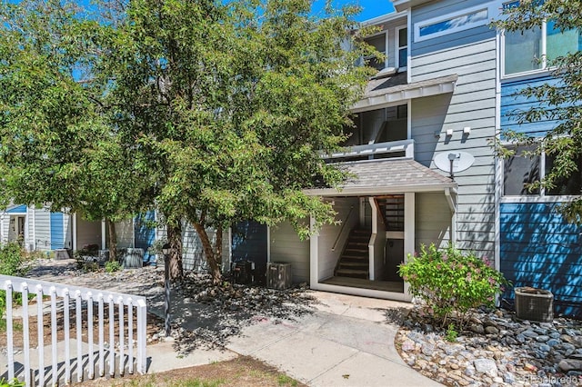 19192 E Wyoming Pl Unit 206, Aurora, CO 80017 - view of front of home with stairs, central AC unit, and roof with shingles