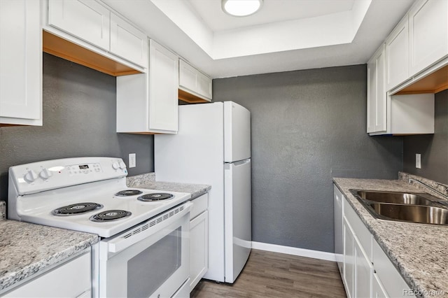 19192 E Wyoming Pl Unit 206, Aurora, CO 80017 - kitchen featuring white electric range oven, a sink, white cabinets, baseboards, and a textured wall