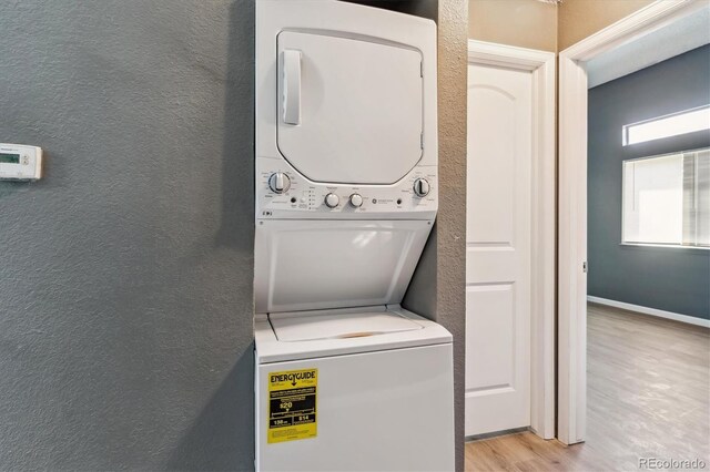 19192 E Wyoming Pl Unit 206, Aurora, CO 80017 - laundry area featuring stacked washer / dryer, a textured wall, and light wood finished floors