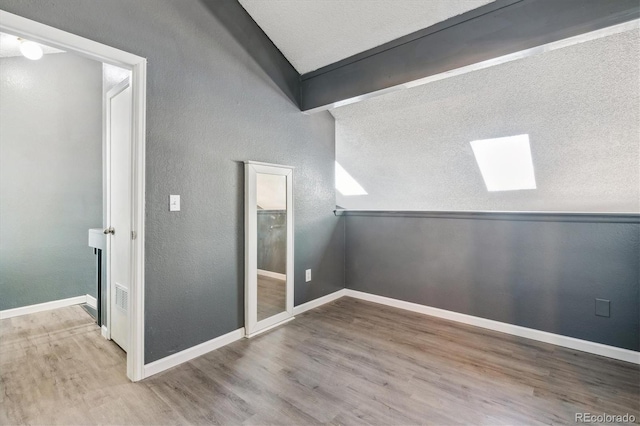 19192 E Wyoming Pl Unit 206, Aurora, CO 80017 - spare room with a skylight, wood finished floors, lofted ceiling, and baseboards