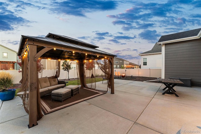 patio terrace at dusk featuring a gazebo and outdoor lounge area