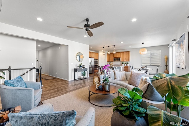 living room featuring ceiling fan and hardwood / wood-style flooring