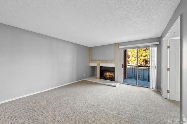 unfurnished living room with light colored carpet and a textured ceiling