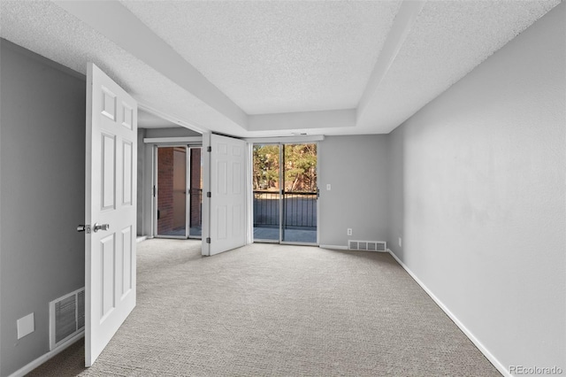 unfurnished room featuring a textured ceiling and light carpet