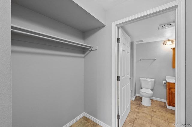 bathroom featuring tile patterned flooring, vanity, and toilet