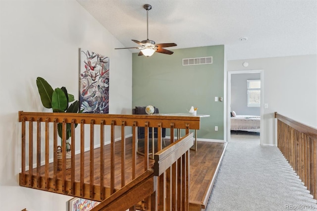 hallway featuring a textured ceiling, hardwood / wood-style flooring, and vaulted ceiling