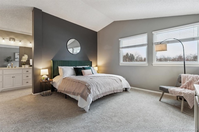 carpeted bedroom featuring a textured ceiling, connected bathroom, and vaulted ceiling