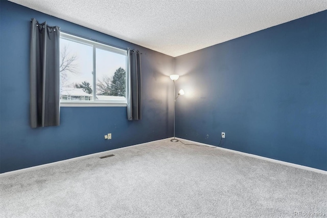 carpeted spare room featuring a textured ceiling