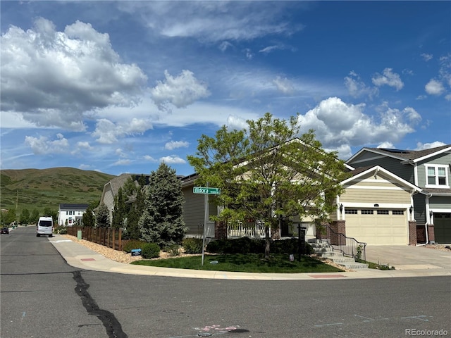 6013 Eldora St, Golden, CO 80403 - view of front facade with brick siding, a mountain view, and driveway