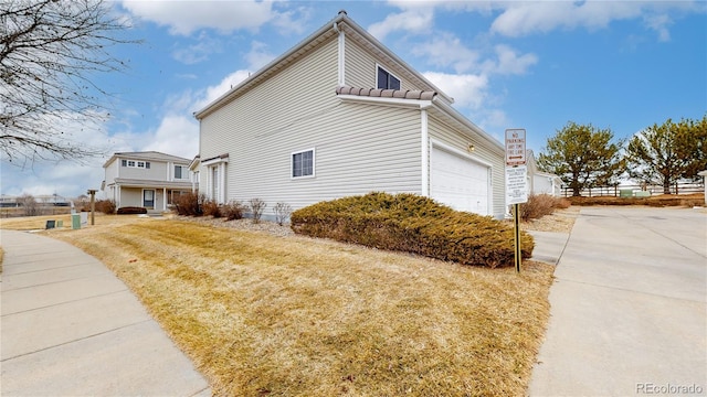 view of side of home featuring a yard and an attached garage