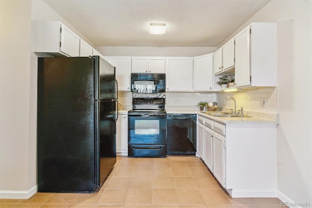 kitchen with black appliances, a sink, tasteful backsplash, white cabinets, and light countertops