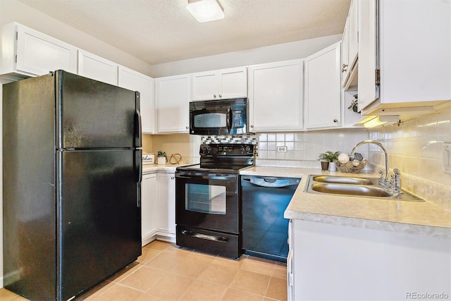 kitchen featuring light countertops, backsplash, a sink, black appliances, and white cabinetry