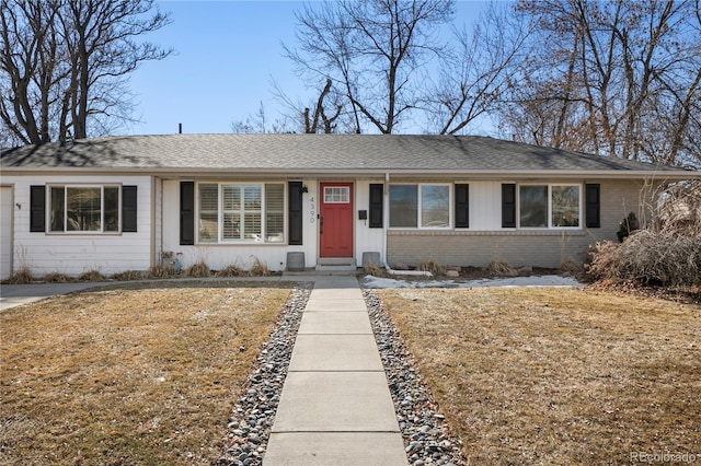 ranch-style house with brick siding, board and batten siding, and a front lawn