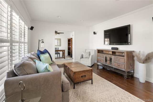 living area with baseboards, ornamental molding, and wood finished floors