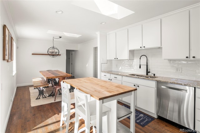 kitchen with a skylight, butcher block counters, a sink, and dishwasher