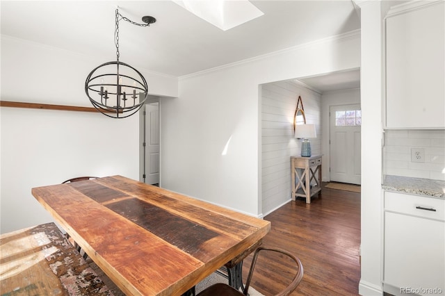 dining room featuring a skylight, ornamental molding, and dark wood-style flooring