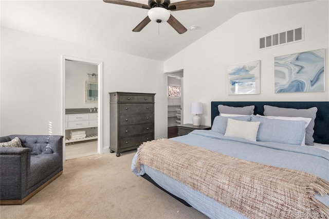 bedroom featuring visible vents, carpet flooring, vaulted ceiling, ceiling fan, and ensuite bath