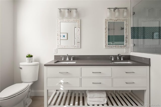 full bath featuring a stall shower, a sink, toilet, and double vanity